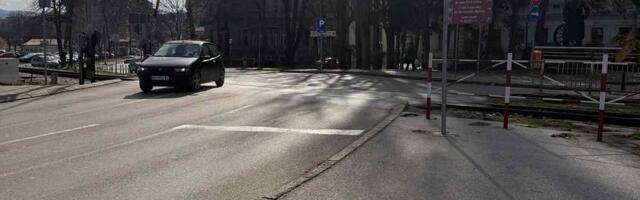 Rampa podignuta, automobili prolaze između vozova