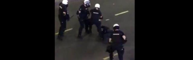 Više pripadnika žandarmerije udara muškarca koji leži na ulici