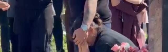 Majka Branka jeca sedi kod Draganovog groba i jeca, Darko je mazi po glavi: